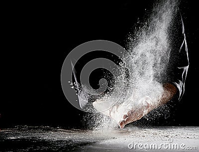 Cloud of flour spraying into air as man rubs hands Stock Photo