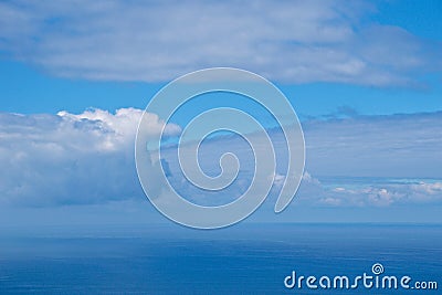 Cloud formations in blue sky mingle with sea in Spain Stock Photo