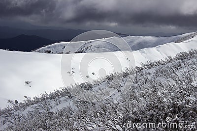 Cloud looming over snow covered mountains Stock Photo