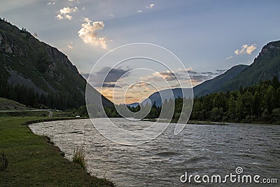 Cloud over the mountain range. Blue sky and green grass in the valley of a mountain river Stock Photo