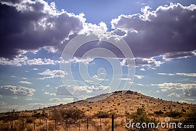 Stormy sky and promising rain clouds over a dry Kalahari desert hill Stock Photo