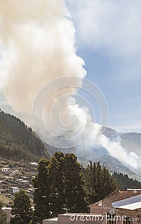 Cloud of smoke caused by a forest fire on mountains in the Yungas zone, in Quime, Bolivia Stock Photo