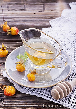 Cloudberry honey in a gravy boat on saucer with ripe berries arctic cloudberries Stock Photo