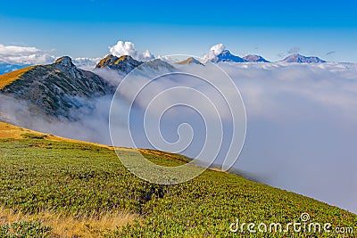 Clouds cover mountain tops at autumn evening time. Stock Photo