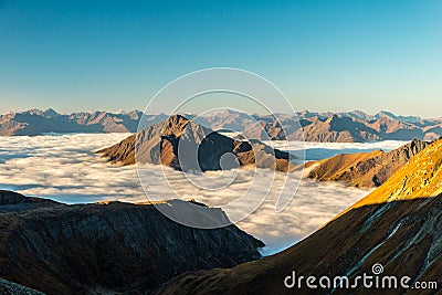 Clouds sea floating in alpine valley in sunrise in autumn, Grossglockner area, Tyrol, Austria Stock Photo