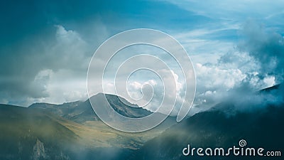 Clouds and fog cover the snowy mountain top and gorge. The beauty of nature. Photo for desktop wallpaper. Stock Photo