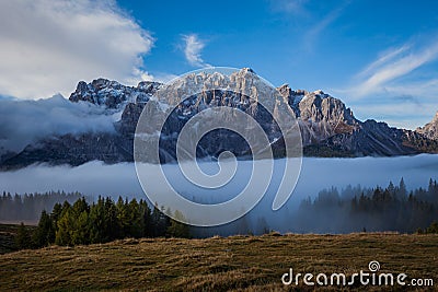 Clouds and fog at dawn from which the wonderful peaks of the Dolomites spring up Stock Photo