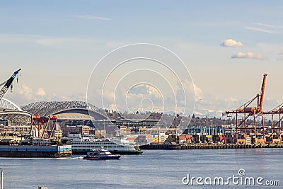 Clouds forming and moving in front of Mt. Rainier and part of the harbor island with containers in the Elliott Bay in Seattle, Stock Photo