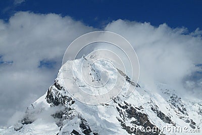 Clouds on high mountain snow peak Stock Photo