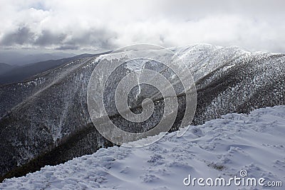 Clouds looming over snow capped mountain Stock Photo