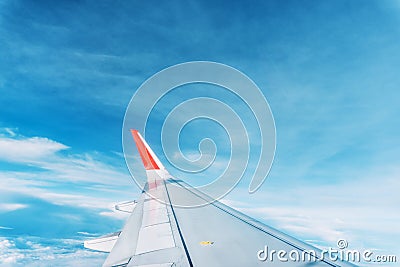 Clouds, sky and wing aeroplane as seen through window of an aircraft Stock Photo