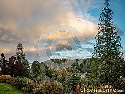 Clouds start to turn orange at sunset looking out over the fall colors near Stonefield Castle in Argyll and Bute Scotland UK Stock Photo