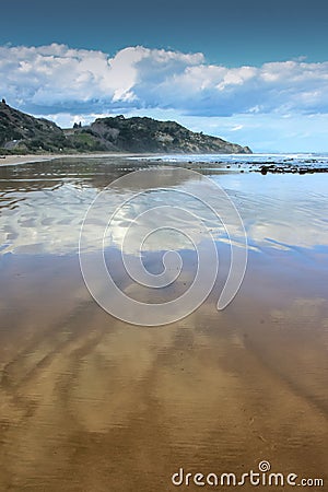 Cloudscapes reflected in wet sand on Makorori Beach, Gisborne, New Zealand Stock Photo