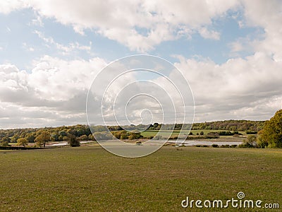 Cloudy blue sky over a country meadow grassland Stock Photo