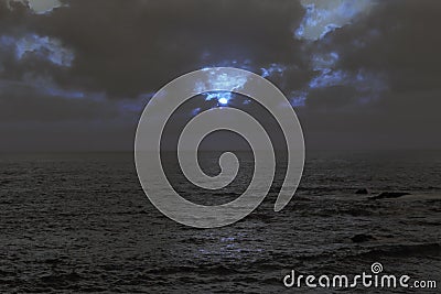 Cloudy full moon night at sea Stock Photo