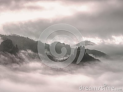 Cloudy hilly landscape. View over heavy cloud into rocky gulch Stock Photo