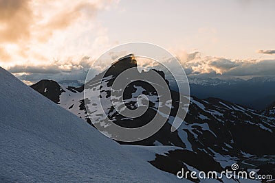 Cloudy moody sunset in snow mountains above Garibaldi Lake on Panorama Ridge Stock Photo