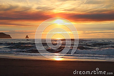 Cloudy skies and sunset over Oregon Coast Pacific ocean rocky outcrops Stock Photo