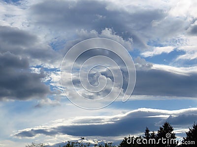Cloudy sunset. Grey clouds in the blue sky. Stormy, cloudy, rainy, gloomy weather forecast concept. Stock Photo