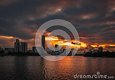 Cloudy sunset over Yekaterinburg business center reflecting in water of pond Stock Photo