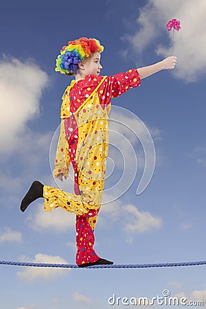 Clown as a tightrope walker with flower Stock Photo