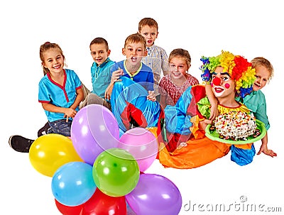 Clown holding cake on birthday with group children. Stock Photo