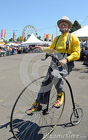 Clown on Penny Farthing Bicycle Editorial Stock Photo