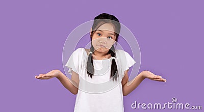 Clueless Korean Girl Shrugging Shoulders Standing Over Purple Studio Background Stock Photo