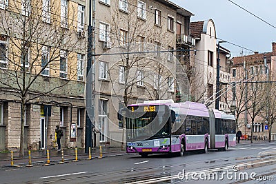 CLUJ-NAPOKA, ROMANIA - April 27, 2022. Trolleybus Solaris Trollino 18 #303 riding with passengers in the streets of Cluj-Napoka. Editorial Stock Photo