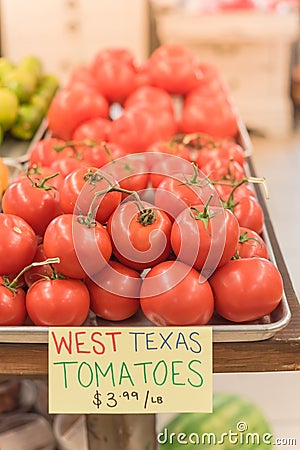 Cluster juicy tomatoes display at farmer market with price sign Stock Photo