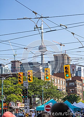 The CN Tower seen through street lights and streetcar cables on Dundas near Chinatown Editorial Stock Photo