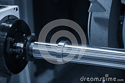 The CNC cylindrical grinding machine with the steel shaft. Stock Photo