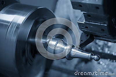 The CNC lathe machine in metal working process cutting the metal shaft parts with the cutting tools. Stock Photo