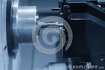 The CNC lathe machine in metal working process cutting the screw and nut parts with the cutting tools. Stock Photo