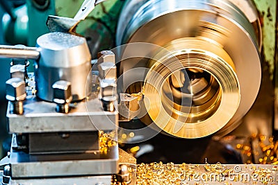 A cnc lathe worker makes a round piece of bronze Stock Photo