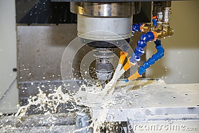 The CNC milling machine cutting the injection mould parts with the coolant method. Stock Photo