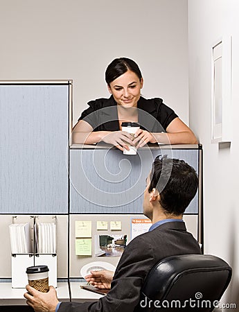 Co-workers talking in office cubicle Stock Photo