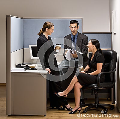 Co-workers talking in office cubicle Stock Photo