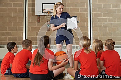 Coach Giving Team Talk To Elementary School Basketball Team Stock Photo