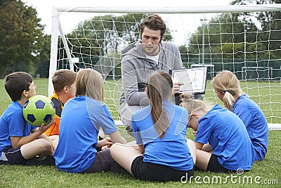 Coach Giving Team Talk To Elementary School Soccer Team Stock Photo