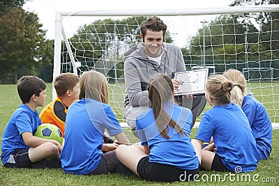 Coach Giving Team Talk To Elementary School Soccer Team Stock Photo