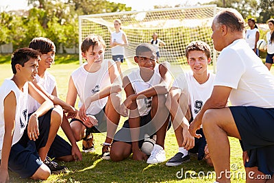 Coach Giving Team Talk To Male High School Soccer Team Stock Photo