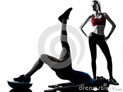 Coach man woman exercising abdominals with bosu Stock Photo
