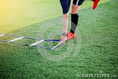 Coach is putting the ladder drills for soccer trainng to run and jump. Fo Stock Photo