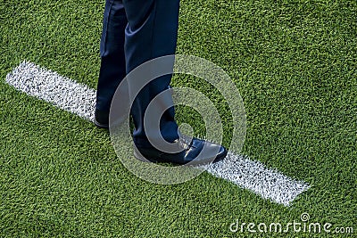 Coach standing next to chalk line on soccer field Stock Photo