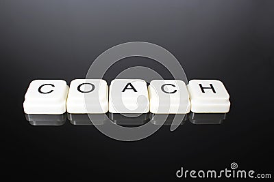Coach text word title caption label cover backdrop background. Alphabet letter toy blocks on black reflective background. White al Stock Photo