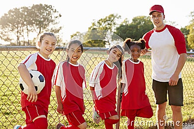 Coach and young girls in a football team looking to camera Stock Photo