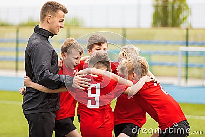 Coaching Youth Sports. Kids Soccer Football Team Huddle with Coach Stock Photo