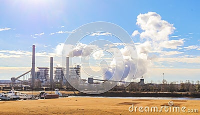 Coal fired power plant on a cold morning with steam and smoke rising - small marina on inlet Stock Photo