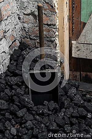 A coal shovel stuck in a pile of coalat the basement Stock Photo